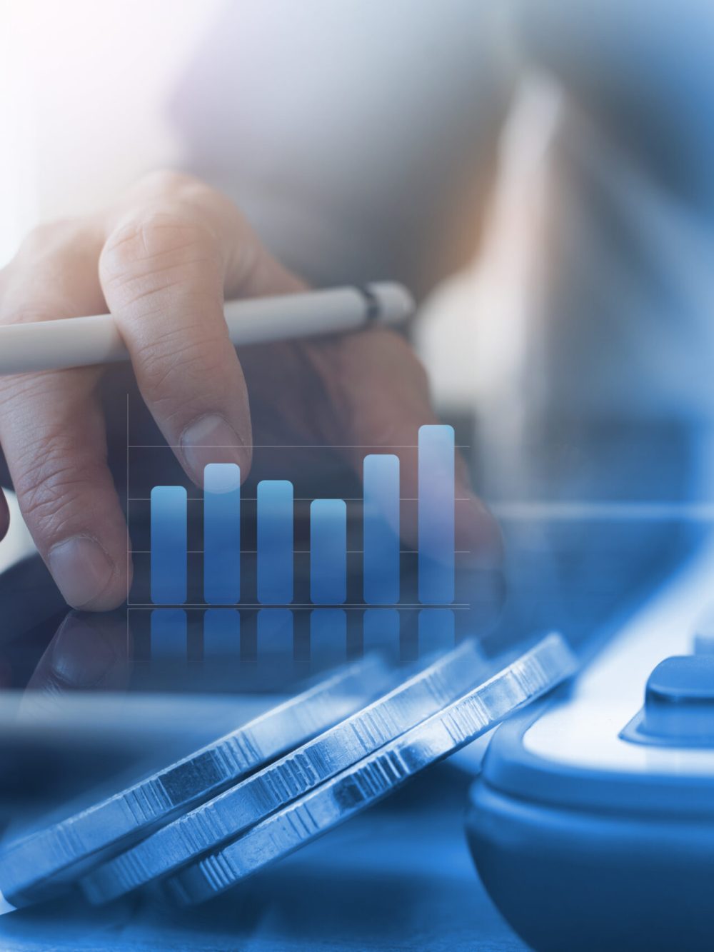 Business analysis, accounting and finance investment concept. Double exposure of business man working on digital tablet and coins with digital diagram, business data, financial graph