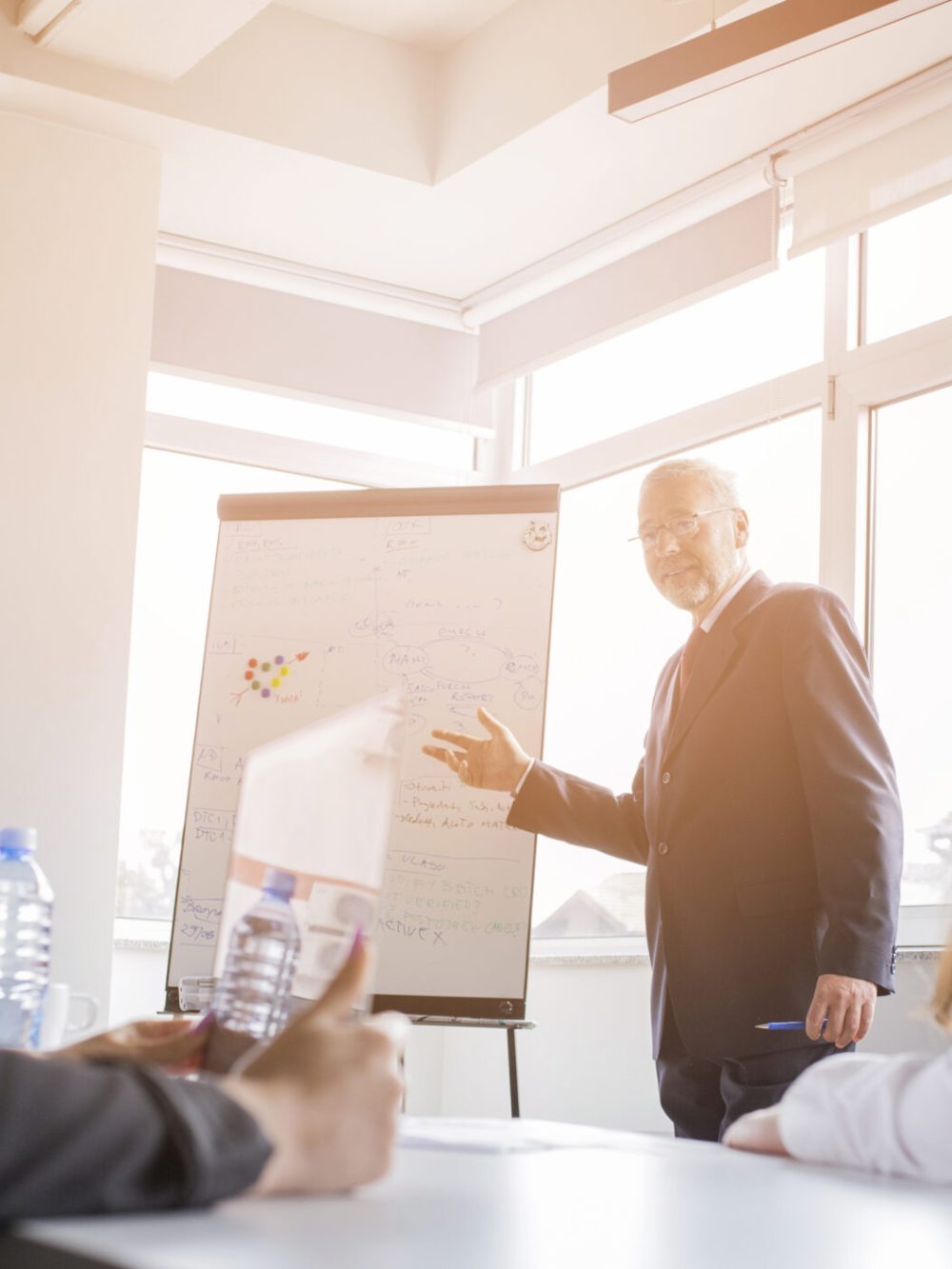 two-businesswoman-looking-businessman-giving-presentation